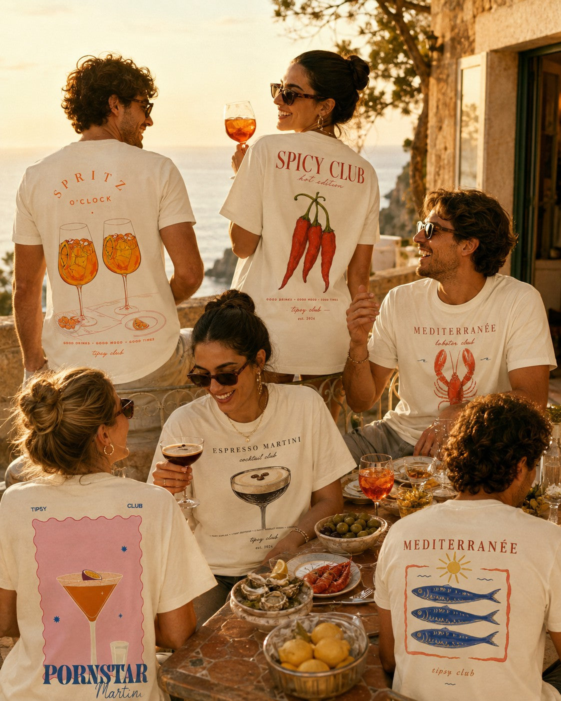 Friends around a terrace table at golden hour wearing Spritz, Spicy Club and Espresso Martini tees