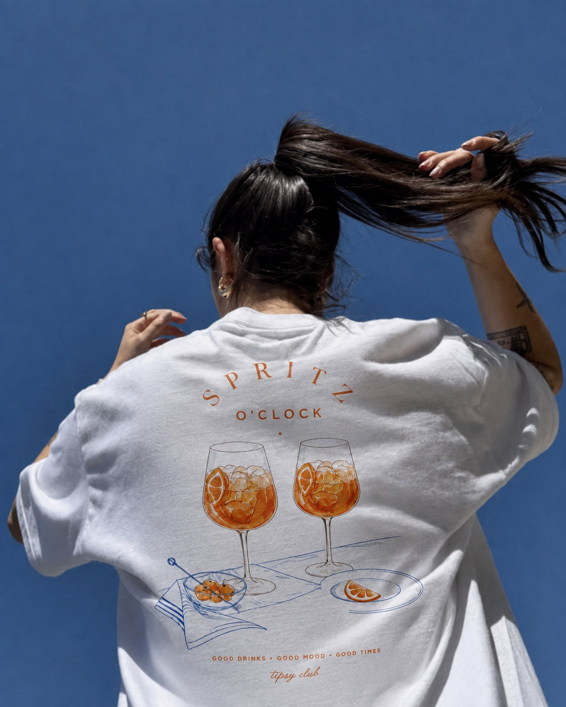 Spritz O'Clock tee against a blue wall